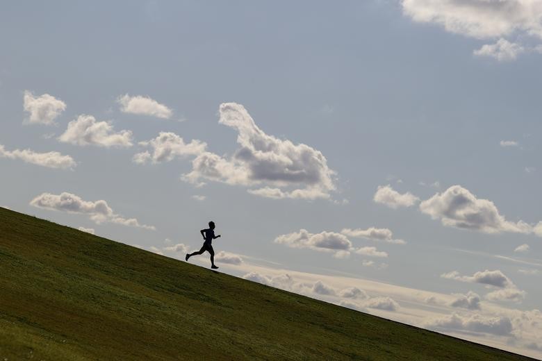 A runner exercises on a hill at Sydney Park amidst the easing of restrictions implemented to curb the spread of the coronavirus in Sydney, Australia.  REUTERS/Loren Elliott  